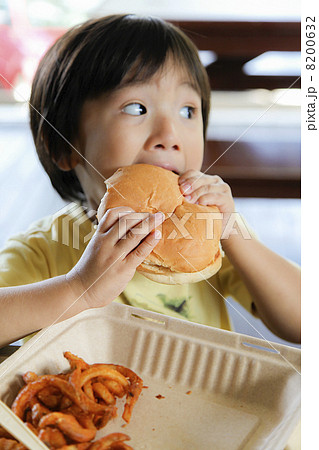 子供 食べる ハンバーガー かぶりつくの写真素材