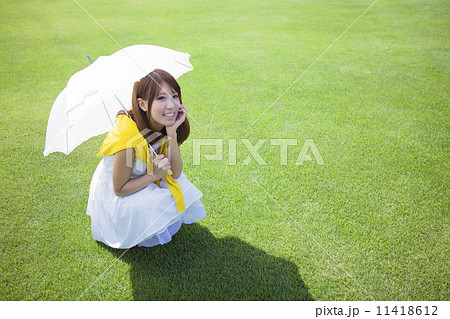 日傘 人物 女性 しゃがむの写真素材