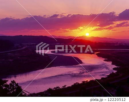 最上川 庄内平野 夕日 逆光の写真素材