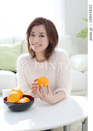 女性 みかん 食べる 果物の写真素材