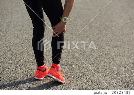 woman runner hold her injured leg on road..