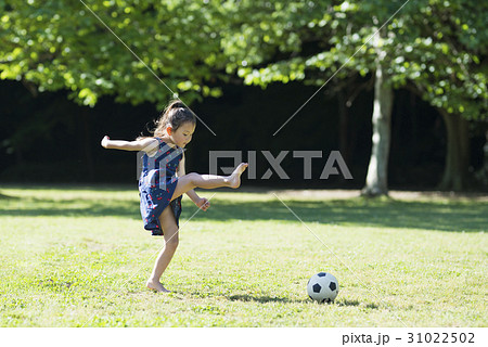 子供 芝生 ボール ワンピースの写真素材