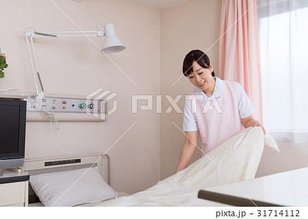 女性 看護師 シーツ ベッドメイキングの写真素材 女性 看護師 シーツ ベッドメイキングの写真素材