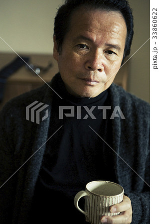 男性 60代 タートルネック カップの写真素材
