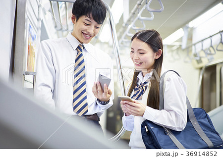 人物 カップル 高校生 電車の写真素材