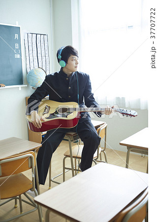 男子学生 男子生徒 アコースティックギター 演奏の写真素材