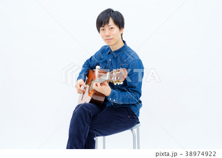 ギター 演奏 座る シャツの写真素材