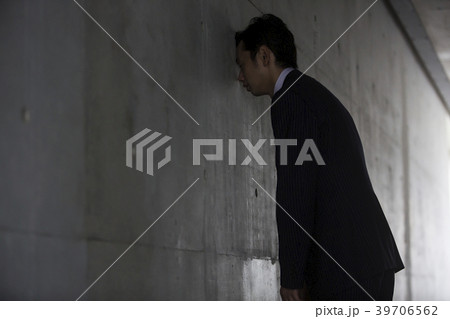 壁に頭をつけるの写真素材