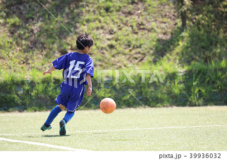 後姿 少年 サッカー ドリブルの写真素材