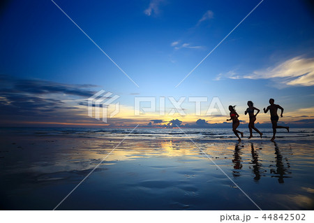 夕焼け 海 カップル 青春 夏 休暇 旅行 男性 シルエットの写真素材