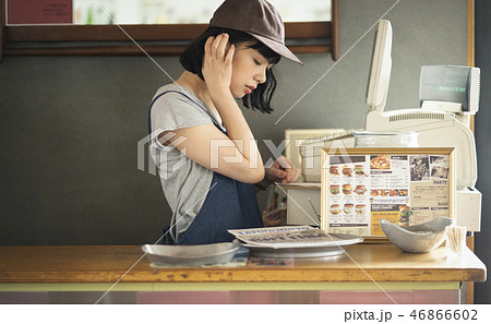 女性 エプロン カフェ店員 キャップの写真素材