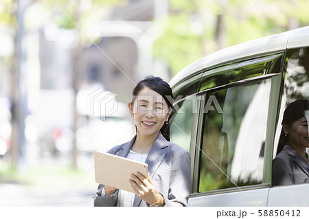 女性 オフィスレディ 営業 車の写真素材