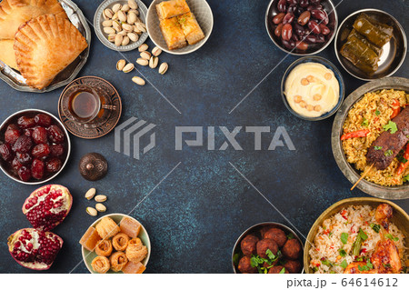 Iftar table in the month of Ramadan, a trip full of varieties of delicious  Saudi Arabian food, the month of Ramadan, Ramadan Kareem, Ramadan lantern,  the background of the mosque. 21955365 Stock