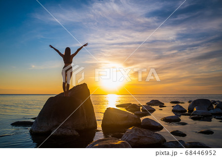 後ろ姿 女性 夕日 海の写真素材