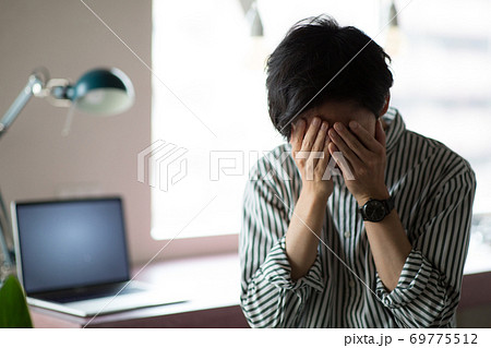 男性 手 覆う 顔の写真素材