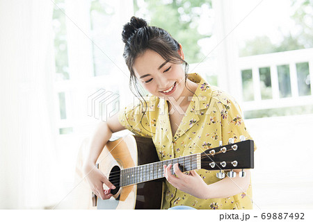 アコースティックギター 女性 女の子 日本人 音楽 弾く 人物の写真素材