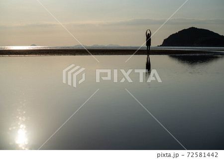 女性 1人 海 影 太陽 人物 夕日 日没の写真素材