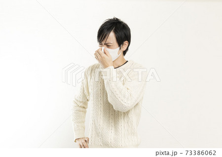 マスク姿の男性/頭痛で頭を抱える/具合が悪い独身男性/	