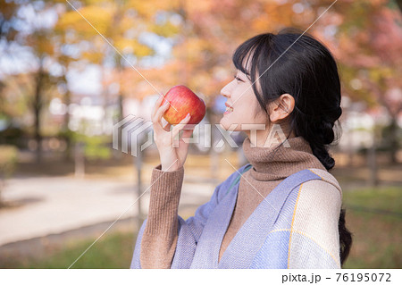 女性 かじる 食べる りんごの写真素材