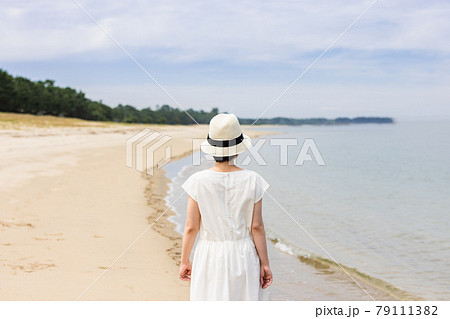 女性 後姿 全身 ワンピース 日本人 青空 砂浜 海の写真素材