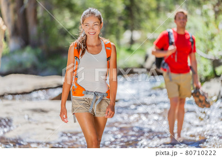 Happy young Asian hiker girl hiking with friend in mountain nature