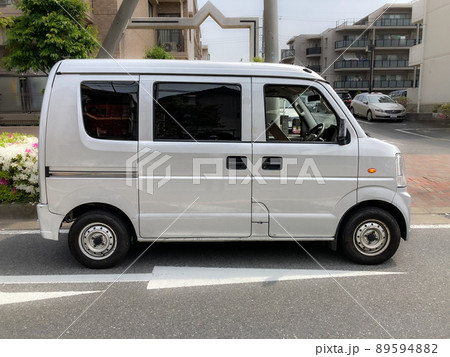 宅配便を住宅街で配送中の軽バン