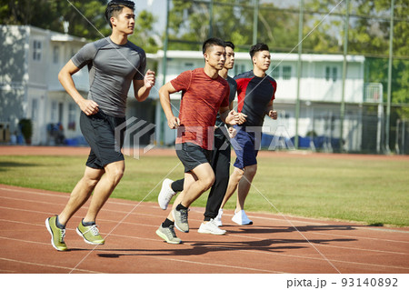 Full length of strong black athlete in sportswear running in neon