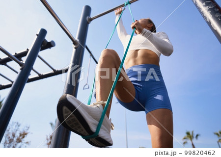 Fitness woman doing pull-ups exercise for back muscles, working