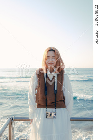 海辺で微笑む女性の写真 海辺で微笑むカメラ女子の写真素材 [138028922] - PIXTA
